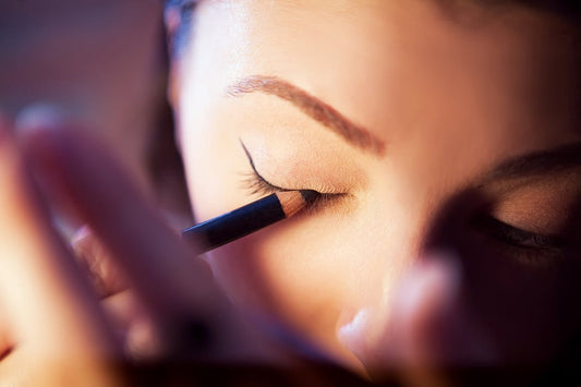 Woman applying eyeliner corrective eyeliner tattoo