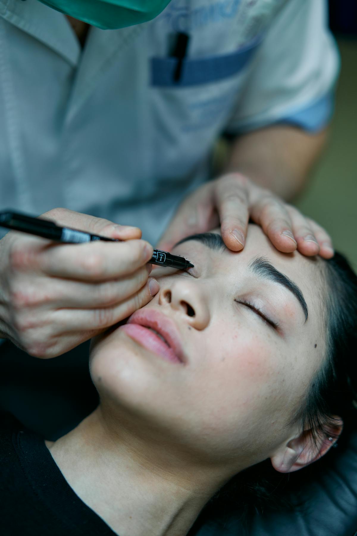 Surgeon marking eyelid top eyeliner tattoo procedure