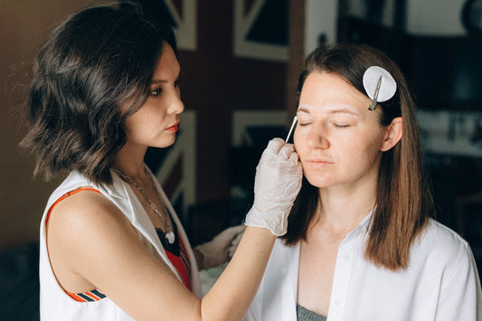 Makeup artist cleaning eyebrow for microblading touch-up